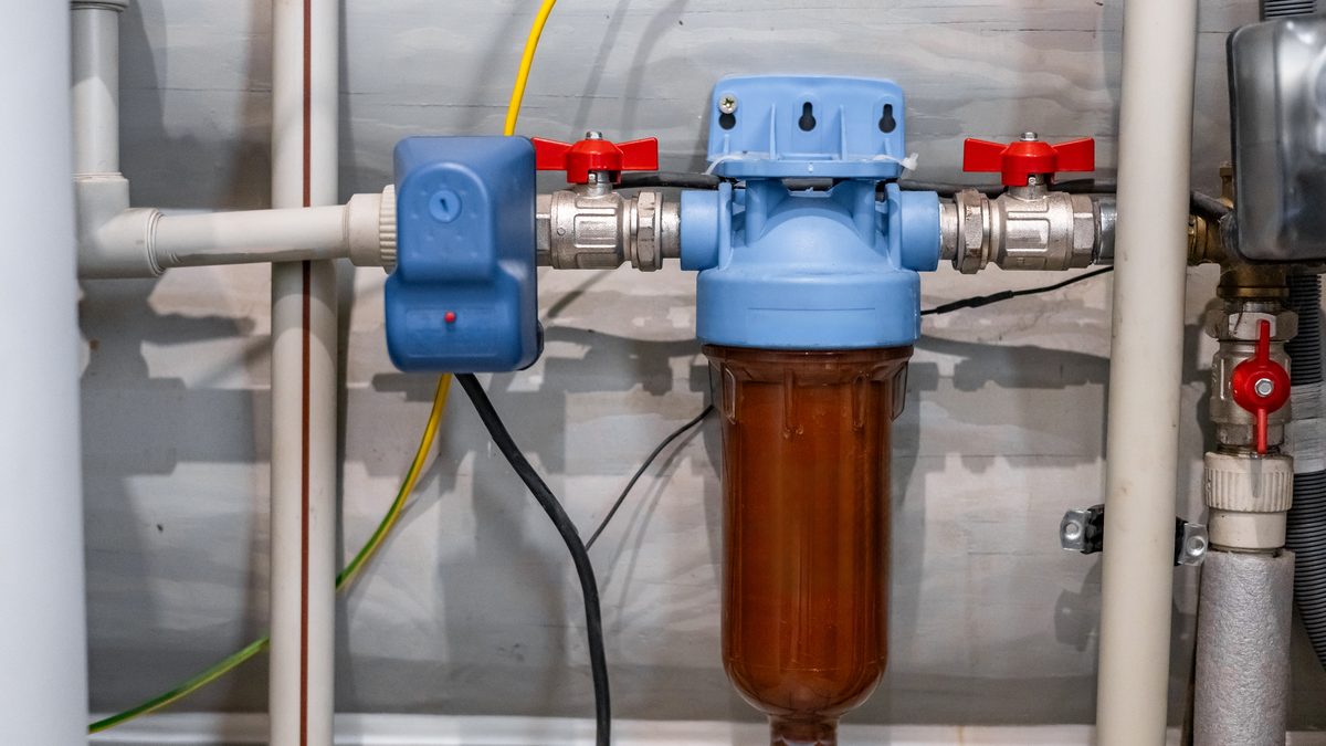 Water filter housing and shutoff valves plumbed into a wall