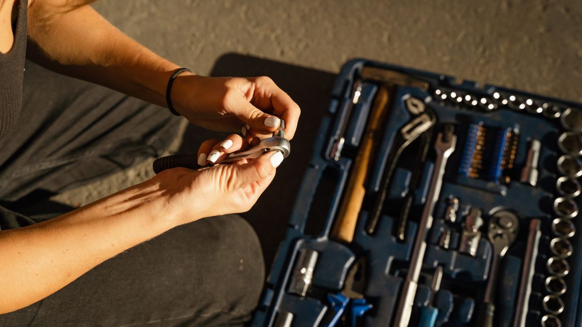 Hands using plumbing tools on a fitting